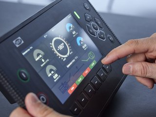 DEIF genset controller with a colour display, operated by hand